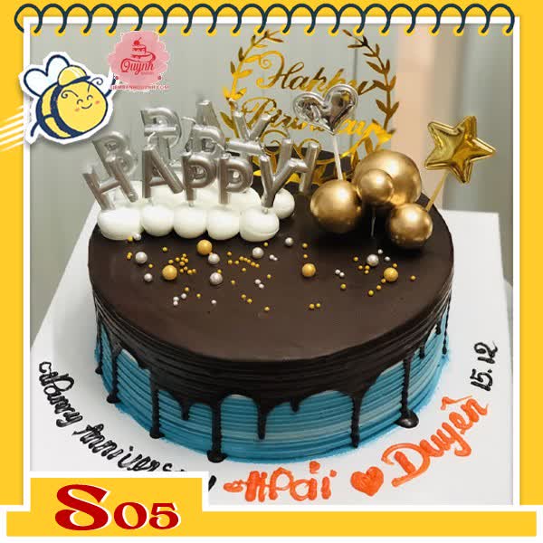 Bánh kem socola S05 phủ trên nền bánh xanh nhạt và cắm nhiều phụ kiện nến bi khung sinh nhật