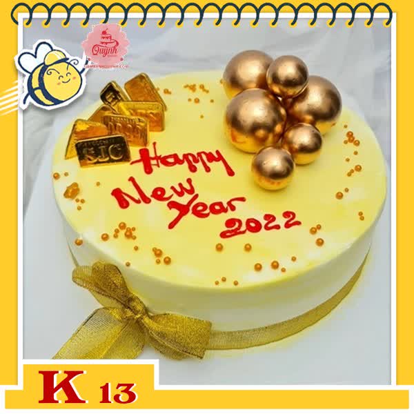 Bánh kem tặng khách hàng K13 nền vàng nhạt thắt nơ và những phụ kiện vàng bạc sang trọng sung túc